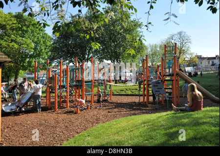 Area giochi per bambini con scivolo e telaio di arrampicata in posizione di parcheggio Foto Stock