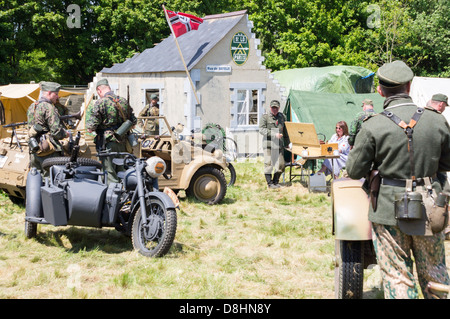 Overlord, D-Day rievocazione a Denmead 2013. I soldati tedeschi, rilassante piedi intorno e parlare. Foto Stock