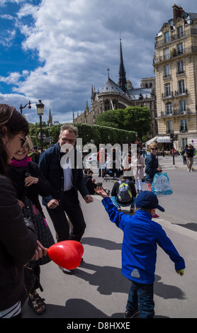 Parigi, Francia. Un padre e un figlio le danze come una jazz band suona nei pressi della cattedrale di Notre Dame (in background) Foto Stock