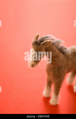 Feltro Cavallo Giocattolo su carta rossa Foto Stock