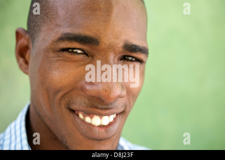 Ritratto di felice giovane americano africano un uomo guarda la fotocamera e sorridente. Testa e spalle, spazio di copia Foto Stock