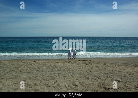 Le monache a piedi sulla spiaggia Foto Stock