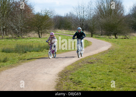 Un ragazzo e una ragazza equitazione biciclette Foto Stock