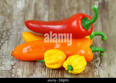 Peperoni misti su sfondo di legno Foto Stock