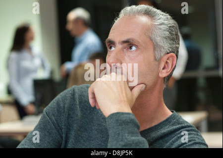 Uomo maturo contemplando in ufficio Foto Stock