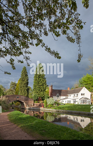 Riflessioni sulla Staffs & Worcester Canal a cavallo di Whittington Bridge, Staffordshire, England, Regno Unito Foto Stock