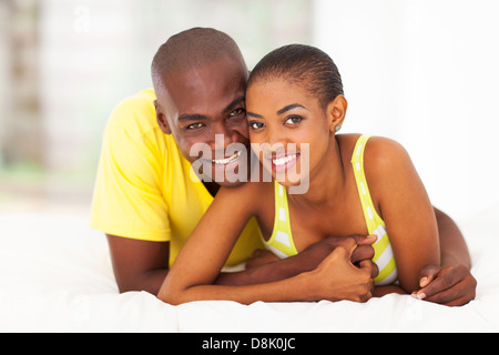 Felice giovane africano giovane rilassante sul letto insieme Foto Stock
