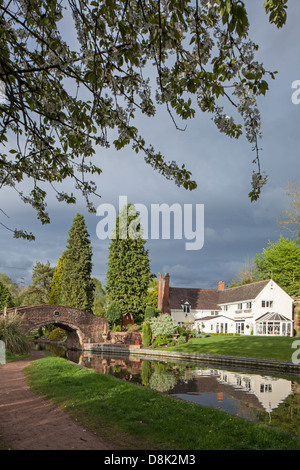 Riflessioni sulla Staffs & Worcester Canal a cavallo di Whittington Bridge, Staffordshire, England, Regno Unito Foto Stock