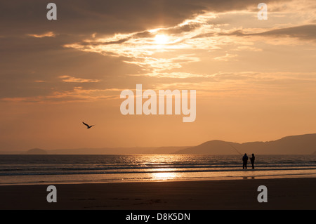 Tramonto a Newgale beach, Pembrokeshire, West Wales (U.K). Con la pesca in spiaggia & gull. Cancellazione di tempesta. Foto Stock