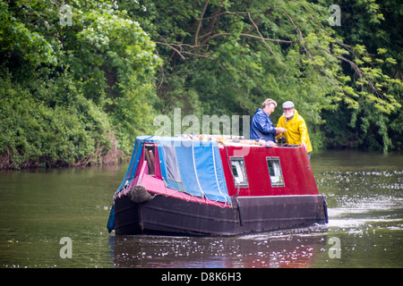 Una stretta motori barca lentamente lungo il fiume Nene su una giornata di primavera Foto Stock