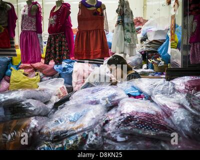 31 maggio 2013 - Bangkok, Tailandia - un fornitore legge un giornale mentre lei attende i clienti nel mercato Bobae in Bangkok. Mercato Bobae è una trentennale famosa per la Moda Ingrosso e ora è molto popolare con gli esportatori di tutto il mondo. Bobae Tower è vicino al mercato e pubblicizza come avente 1.300 bancarelle sotto un unico tetto e rivendica di essere il più grande capo di abbigliamento Centro ingrosso in Thailandia. (Credito Immagine: © Jack Kurtz/ZUMAPRESS.com) Foto Stock