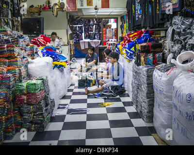 31 maggio 2013 - Bangkok, Thailandia - Lavoratori vestiti bundle per la spedizione in un mercato in stallo nel mercato Bobae in Bangkok. Mercato Bobae è una trentennale famosa per la Moda Ingrosso e ora è molto popolare con gli esportatori di tutto il mondo. Bobae Tower è vicino al mercato e pubblicizza come avente 1.300 bancarelle sotto un unico tetto e rivendica di essere il più grande capo di abbigliamento Centro ingrosso in Thailandia. (Credito Immagine: © Jack Kurtz/ZUMAPRESS.com) Foto Stock