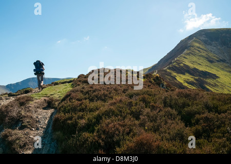 Una femmina di escursionista salendo il crinale al Vertice di Grisedale Pike con uno zaino pesante. Foto Stock