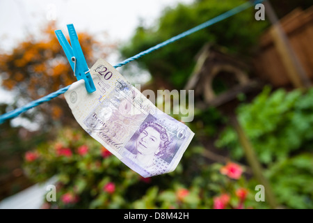 Una ventina di pound nota appeso a un linea di panni Foto Stock