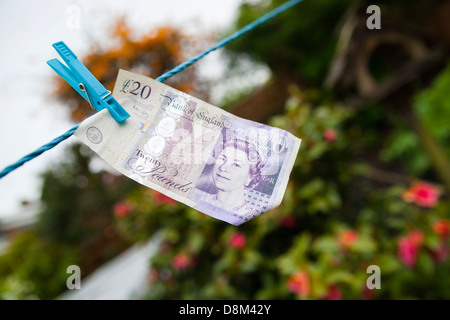 Una ventina di pound nota appeso a un linea di panni Foto Stock