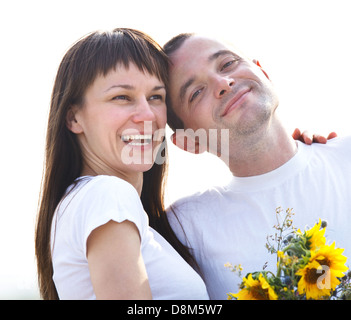 Felice coppia giovane con fiori Foto Stock