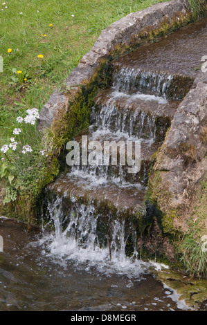 Funzione di acqua con acqua increspata scorre su scalini di pietra, vista dalla parte inferiore di passaggi, soleggiato, luccicante, ondulazioni, cascading Foto Stock