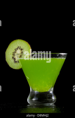 Stemless martini con un vivace verde drink guarnito con una fetta di kiwi Foto Stock