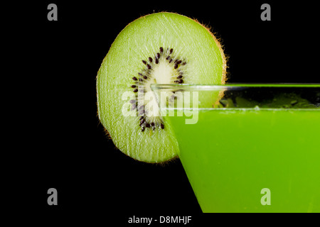 Stemless martini con un vivace verde drink guarnito con una fetta di kiwi Foto Stock