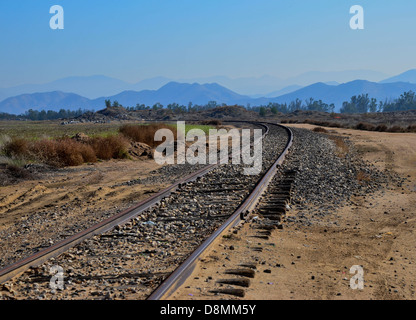 Vecchio, abbandonati e rusty i binari della ferrovia scompaiono in distanza. Foto Stock