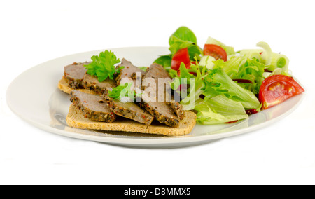 Fette di bistecca di peppe servita sulla sommità di Melba toast su uno sfondo bianco. Foto Stock