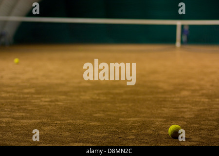 Palla da tennis sulla corte e i ragazzi in background Foto Stock