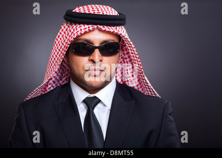 Facoltoso imprenditore arabo indossando occhiali da sole su sfondo nero Foto Stock