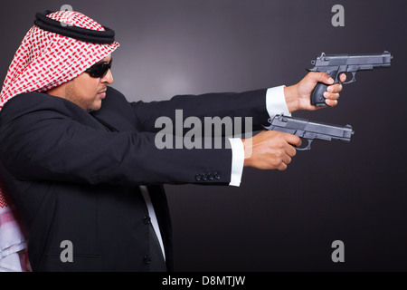 Pericoloso arabian uomo colpito tiro con due cannoni su sfondo nero Foto Stock