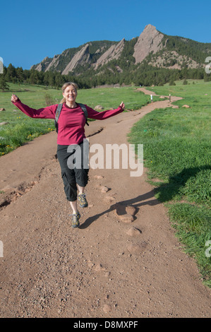 Donna allegra sul sentiero escursionistico di fronte montagne. Foto Stock