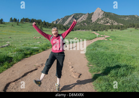 Excited donna salti in aria sul sentiero. Foto Stock