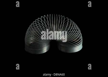 Slinky giocattolo a molla su sfondo nero Foto Stock