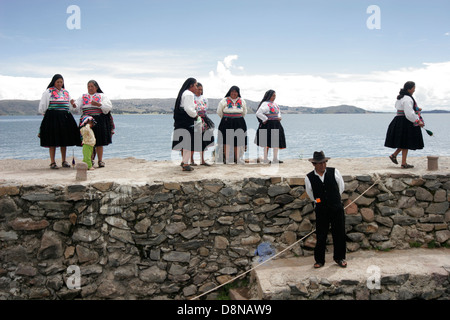 Persone locali riuniti i turisti sul molo di Isola Amantani, il lago Titicaca, Perù, Sud America Foto Stock