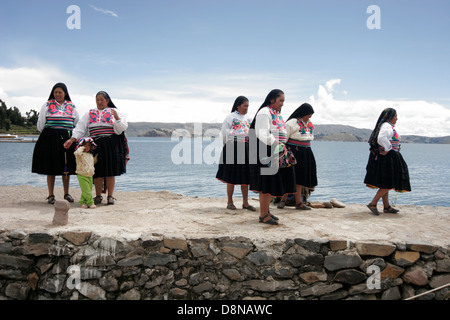 Persone locali riuniti i turisti sul molo di Isola Amantani, il lago Titicaca, Perù, Sud America Foto Stock