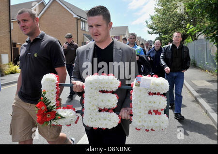 LUTON, Regno Unito. Il 1 giugno 2013. La Difesa inglese League tenere una silenziosa passeggiata nel memoriale del soldato Lee Rigby che fu ucciso a Woolwich il mese scorso. I leader dell'EDL Tommy Robinson (vero nome Stephen Yaxley-Lennon, raffigurato, che trasportano fiori) e Kevin Carroll condurre una passeggiata attraverso la città al memoriale di guerra al di fuori del municipio. Credito: Polly Thomas / Alamy Live News Foto Stock