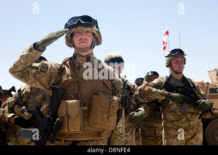 Soldati georgiani salute durante la riproduzione del Georgian National Anthem Maggio 26, 2013 a Camp Leatherneck, Afghanistan. Il Presidente della Repubblica di Georgia Mikheil Saakashvili, ha viaggiato alla base di partecipare ad una indipendenza georgiana cerimonia della giornata. Foto Stock