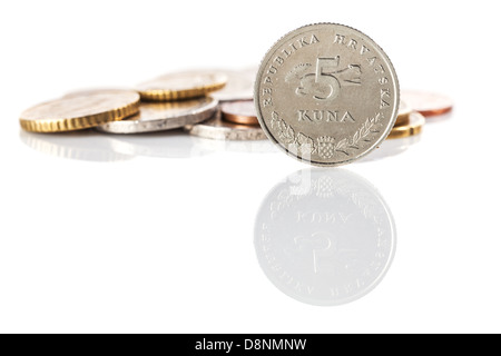 Una standing 5 kuna coin - Moneta croata - di fronte al mucchio di euro e centesimi di euro su bianco superficie riflettente Foto Stock