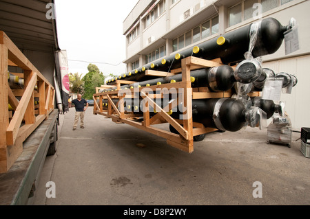 Un carrello di caricamento di un carrello elevatore con un pallet irregolari di tubazioni in plastica Foto Stock