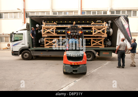 Un carrello di caricamento di un carrello elevatore con un pallet irregolari di tubazioni in plastica Foto Stock