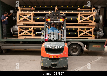 Un carrello di caricamento di un carrello elevatore con un pallet irregolari di tubazioni in plastica Foto Stock