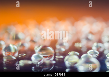 Abstract di gocce di acqua macro shot su una superficie riflettente Foto Stock