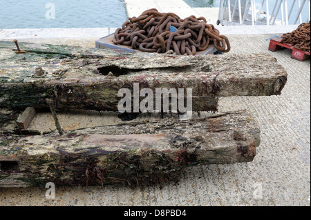 Marciume pier pali di legno rimosso dal molo di swanage dai contraenti jenkins marine Engand Dorset Regno Unito Foto Stock