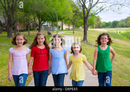 I bambini gruppo di sorelle ragazze e amici a piedi felici nel parco all'aperto Foto Stock