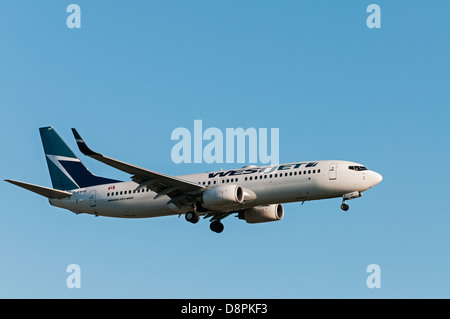 Un Westjet Boeing 737-800 (C-GWBL) jetliner in volo e sull approccio finale per l'atterraggio all'Aeroporto Internazionale di Vancouver. Foto Stock