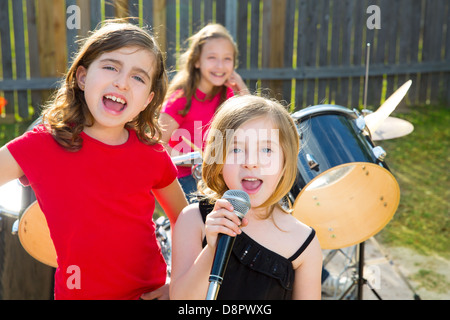 Ragazzo biondo cantante ragazza cantando la riproduzione live band in concerto nel cortile con gli amici Foto Stock