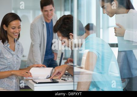 I colleghi che lavorano insieme in ufficio, utilizzando una tavoletta digitale Foto Stock