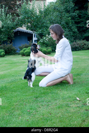 Ragazza che gioca con il cane in cortile Foto Stock