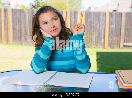 Latino Americana teen girl pensando con matita facendo i compiti sul cortile Foto Stock