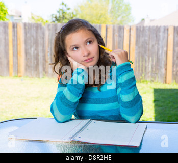 Latino Americana teen girl pensando con matita facendo i compiti sul cortile Foto Stock