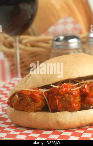 Delizioso sandwich con le polpette con salsa marinara, formaggio e vino. Foto Stock