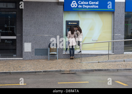 Due giovani donna presso la Caixa Geral de Depositos cash macchina distributrice di São Brás de Alportel Algarve Portogallo Europa Foto Stock